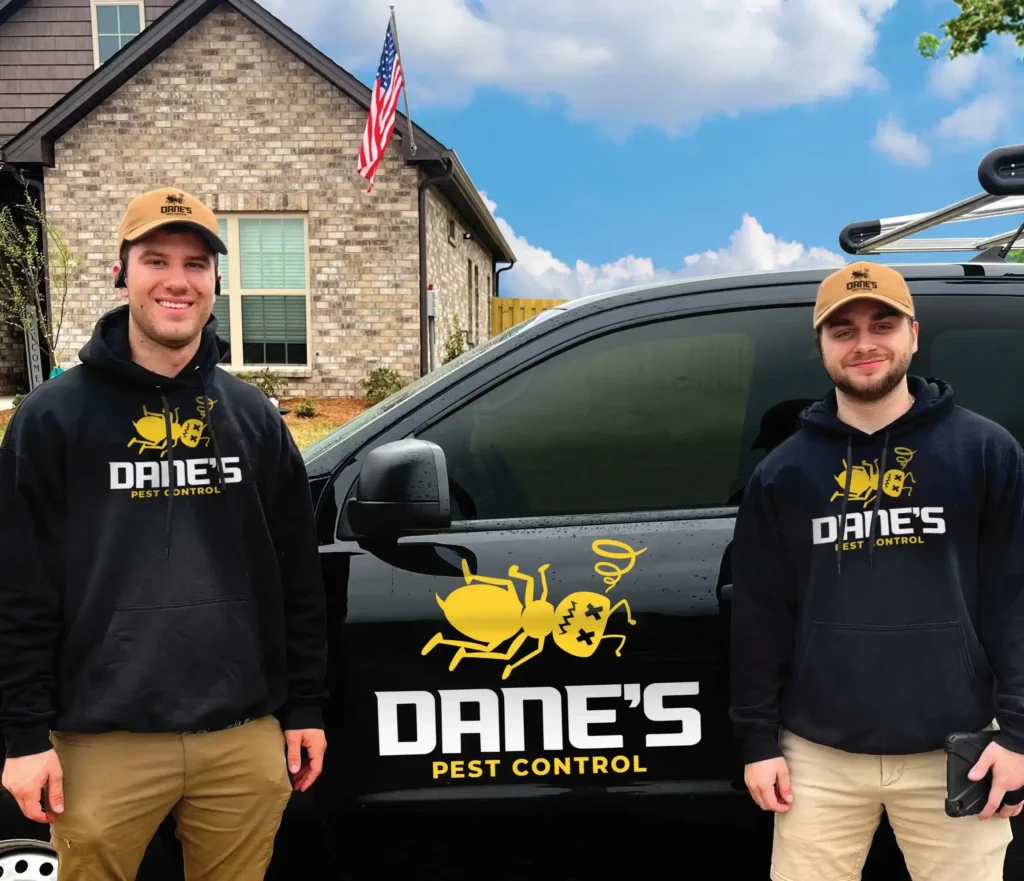 Owners of Dane's Pest Control standing in front of service vehicle after completing a pest control service