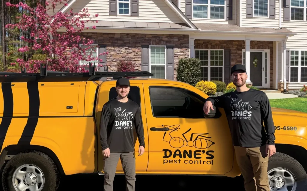 Dane's Pest Control owners in front of a service truck at a customers home in Huntsville Alabama